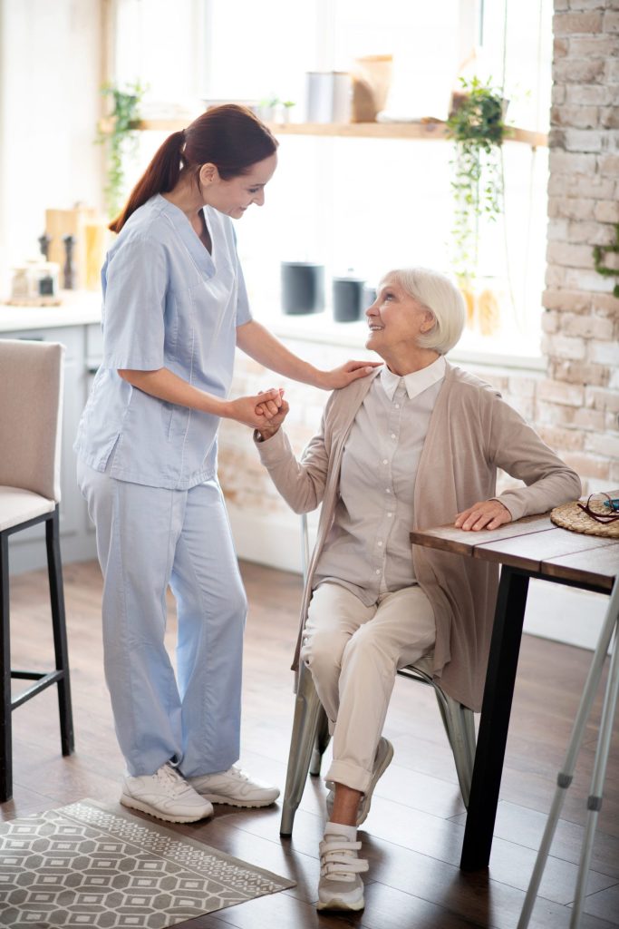 Red-haired caregiver in uniform speaking with patient-Short Term Rehabilitation in Hartwell, GA